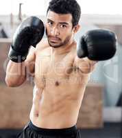 Hell box you into next Tuesday. a handsome young boxer practicing his jab at gym.