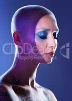 Sophisticated with a hint of sass. Studio shot of an attractive young woman wearing edgy makeup against a blue background.