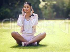 These tunes get me right into zen mode. a sporty young woman listening to music while exercising outdoors.