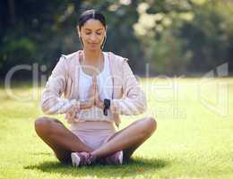 Peace is attainable through focus. a sporty young woman meditating while exercising outdoors.