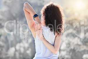 Stretch your body. a sporty young woman stretching while standing outside.