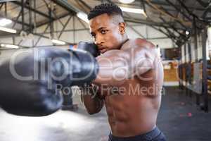 Hes got speed behind those powerful punches. a muscular young man wearing boxing gloves in a gym.