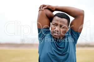 Stretching prompts your brain to switch into workout mode. a sporty young man stretching his arms while exercising outdoors.