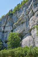 Landscape view of a steep, majestic and rocky mountain cliff on a clear day during summer. Closeup of rocks on a natural mountainside slope. Explore the valley and peak while on a nature adventure