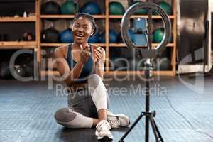 Ill be sharing lots of workout tips with you all today. a sporty young woman recording herself while exercising in a gym.