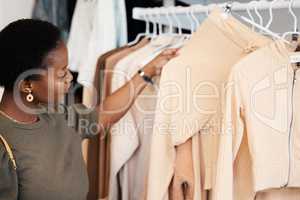 I like this one. a beautiful young woman shopping for clothing at her favourite boutique.