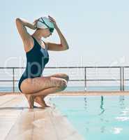 Put the work and time into it. a young female athlete preparing to swim in a pool outside.