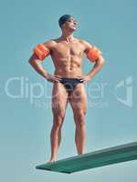 This body shows a commitment to training. Full length shot of a handsome young male athlete standing on a diving board outside.