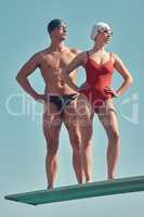 Assured of their swimming pool prowess. Full length shot of two young athletes standing on a diving board outside.