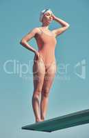 Shes ready to jump. Full length shot of an attractive young female athlete standing on a diving board outside.