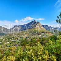 Beautiful view of mountains and houses surrounded by lush green plants against a blue with copy space. Peaceful and scenic Landscape of a peak or hills of Table Mountain and nature on sunny afternoon