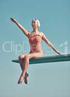 Once youve made it to the top, stay there. Full length shot of an attractive young female athlete sitting on a diving board outside.