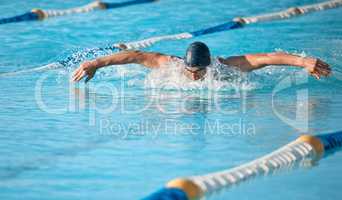 Lap after lap. a handsome young male athlete swimming in an olympic-sized pool.
