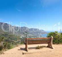 Bench with a beautiful view of Table Mountain and sea against a clear blue sky background with copy space. Relaxing spot for a peaceful break to enjoy the scenic landscape after a hike up a cliff