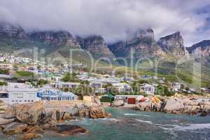 Landscape view of a seaside town along the mountain on a cloudy day in Cape Town, South Africa. Scenic view of a quiet and secluded residential area on the coast for tourists and holidays in summer