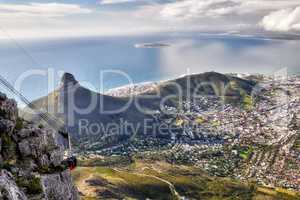 Stunning city, mountain and ocean aerial view with cloudy sky background and copy space. Beautiful landscape of the calm sea on the horizon and Lions Head at a sightseeing location in Cape Town