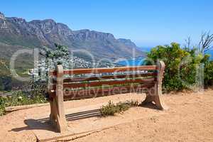 Relaxing resting place along a mountain trail, with beauty in nature and peaceful harmony. Empty bench on Table Mountain, Cape Town, South Africa with a beautiful view of Lions Head and copy space.