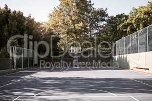 An empty still life of a basketball court on a sunny day with white marking with a hoop and net. A sports ground or court on a club venue for active practices training and outdoor leisure activities