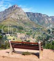 Seating bench in a relaxing mountain range in a botanical garden. Table Mountain National park in Cape Town, South Africa with blue sky and local seating to enjoy calm and zen view of mother nature