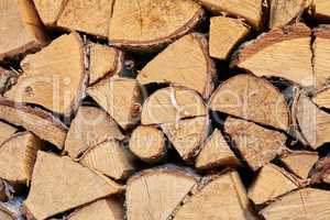 Above view of chopped firewood, logs stacked together in storage pile. Closeup of wooden background and texture. Collecting dry rustic wood as a source of energy. Lumber split hardwood with copyspace