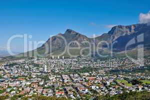 The landscape of an urban town surrounded by green plants and mountains on a summer day. Scenic view of a holiday destination near nature. Aerial view of the beautiful city of Cape Town, South Africa