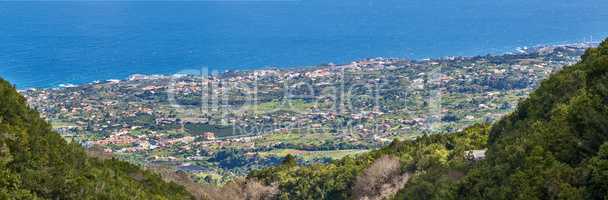 View of the coastal city, Puerto de Tazacorte, from the mountain with the sea in the background from above. Houses or holiday accommodation by the ocean in the tourist destination of La Palma, Spain