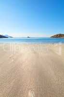 A relaxing beach on a summer day ideal for vacation. Calm, blue ocean, beige sands with islands in the background..An isolated coast in the city of Bodoe, north of the Polar Circle