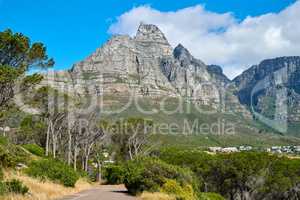 Below view of a mountain peak in South Africa against a cloudy blue sky with copy space. Scenic nature landscape of a remote hiking and travel destination to explore near Table Mountain in Cape Town