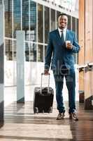 Catching flights not feelings. a young businessman drinking coffee while walking to the airport.