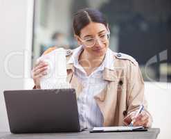 Inspiration doesnt care about your schedule. a young businesswoman using a laptop and making notes while eating at a cafe in the city.