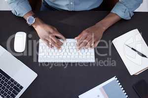 His schedules busy today. High angle shot of an unrecognizable businessperson using a keyboard at work.