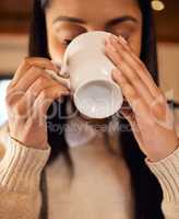 Its all I need to get through the day. a young woman drinking a cup of coffee while sitting at home.