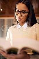Everything you learn will help you in your future. a female student wearing glasses while reading at home.