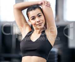 If anyone needs me, Ill be at the gym. Portrait of a fit young woman stretching in a gym.