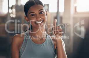 Ill be cheering for you in your fitness journey. Portrait of a sporty young woman showing thumbs up in a gym.