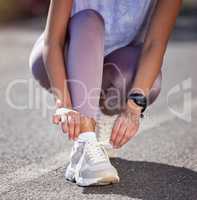 Fasten your laces. an unrecognizable female athlete tying her laces while out for a run.