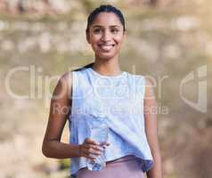 Thinking about the run. an attractive young female athlete taking a break from her outdoor run to drink some water.