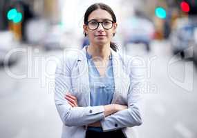 Strength and courage are in. a young businesswoman standing in the street.