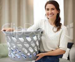 No better distraction. a young woman doing laundry at home.