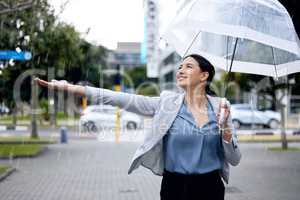 Not afraid to get wet. a young businesswoman enjoying the rain while walking to work.