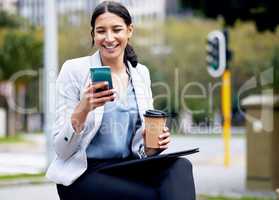 The streets of social media are calling. a beautiful young businesswoman taking a coffee break to use her smartphone.
