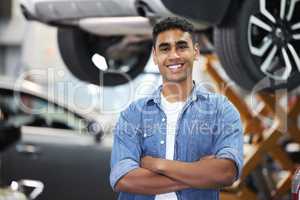 Turned my interest into a career. Portrait of a handsome young mechanic standing with his arms folded in his workshop.