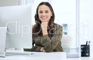 Happy customers are the heart of our organization. Portrait of a young businesswoman using a headset and computer in a modern office.