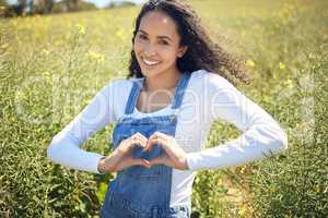 Im a country girl by heart. a beautiful young woman forming a heart shape while standing outdoors.