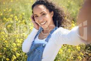 Everyone knows me as the beautiful country girl. a young woman taking a selfie while surrounded by yellow flowers.