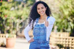 The green life is the way to go. a beautiful young woman showing thumbs up while standing outdoors.