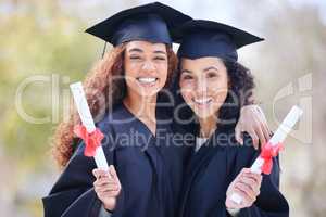 The best is yet to come. Portrait of two young women holding their diplomas on graduation day.