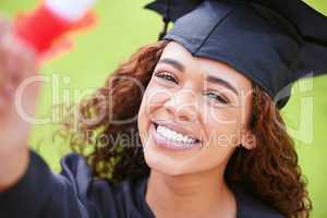 You are brilliant, able and ambitious. Portrait of a young woman holding her diploma on graduation day.