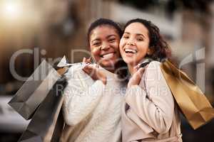 Were not just spending money, were investing in our friendship. Portrait of two young women shopping against an urban background.