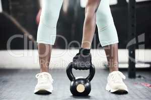 I couldnt imagine my life without the gym. an unrecognisable woman working out in the gym and using a kettlebell.